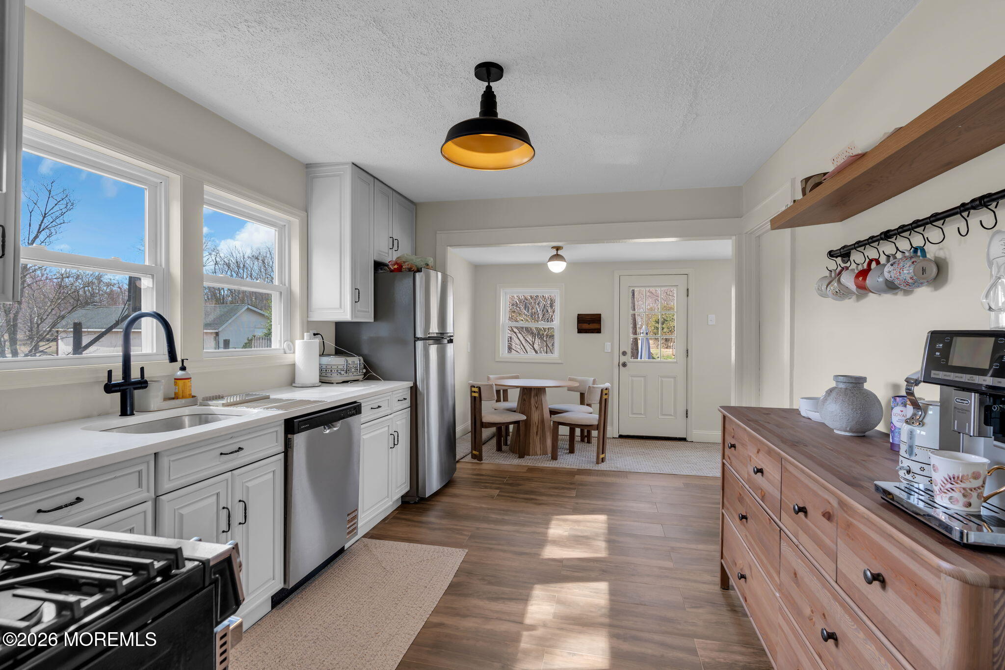 a large kitchen with stainless steel appliances a stove a sink dishwasher and a refrigerator