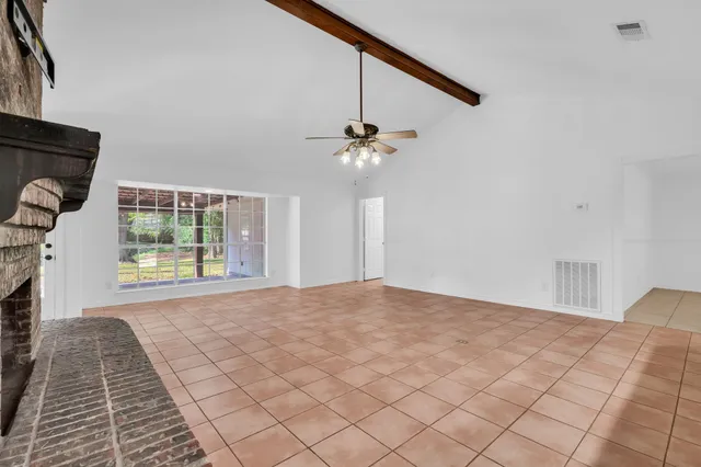 a view of a livingroom with a ceiling fan and window
