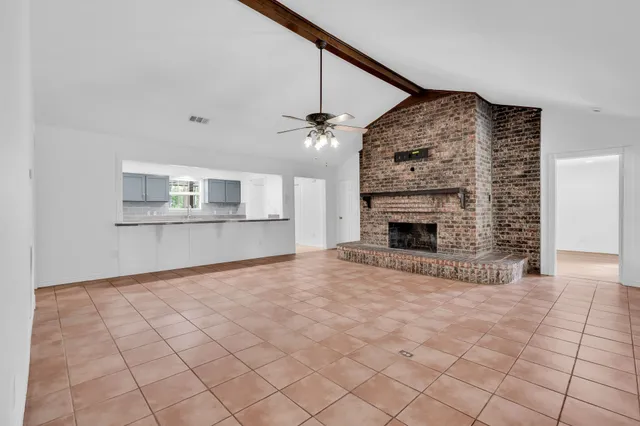 a view of an empty room with a fireplace and a window