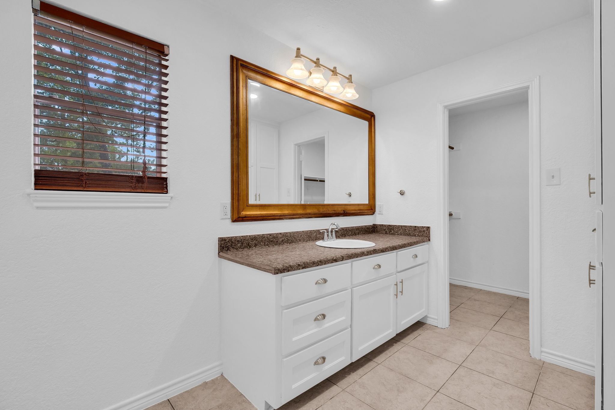 19811 Sagging Oaks Drive Spring, TX 77388 - Photo 19 of 36 a bathroom with a granite countertop sink a mirror and a vanity