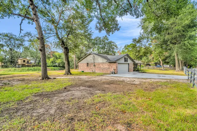 a view of a house with wooden fence and a large tree