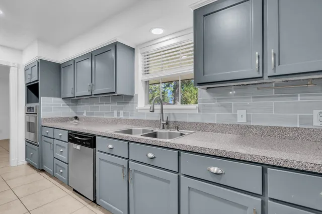 a kitchen with stainless steel appliances granite countertop a sink a stove and cabinets