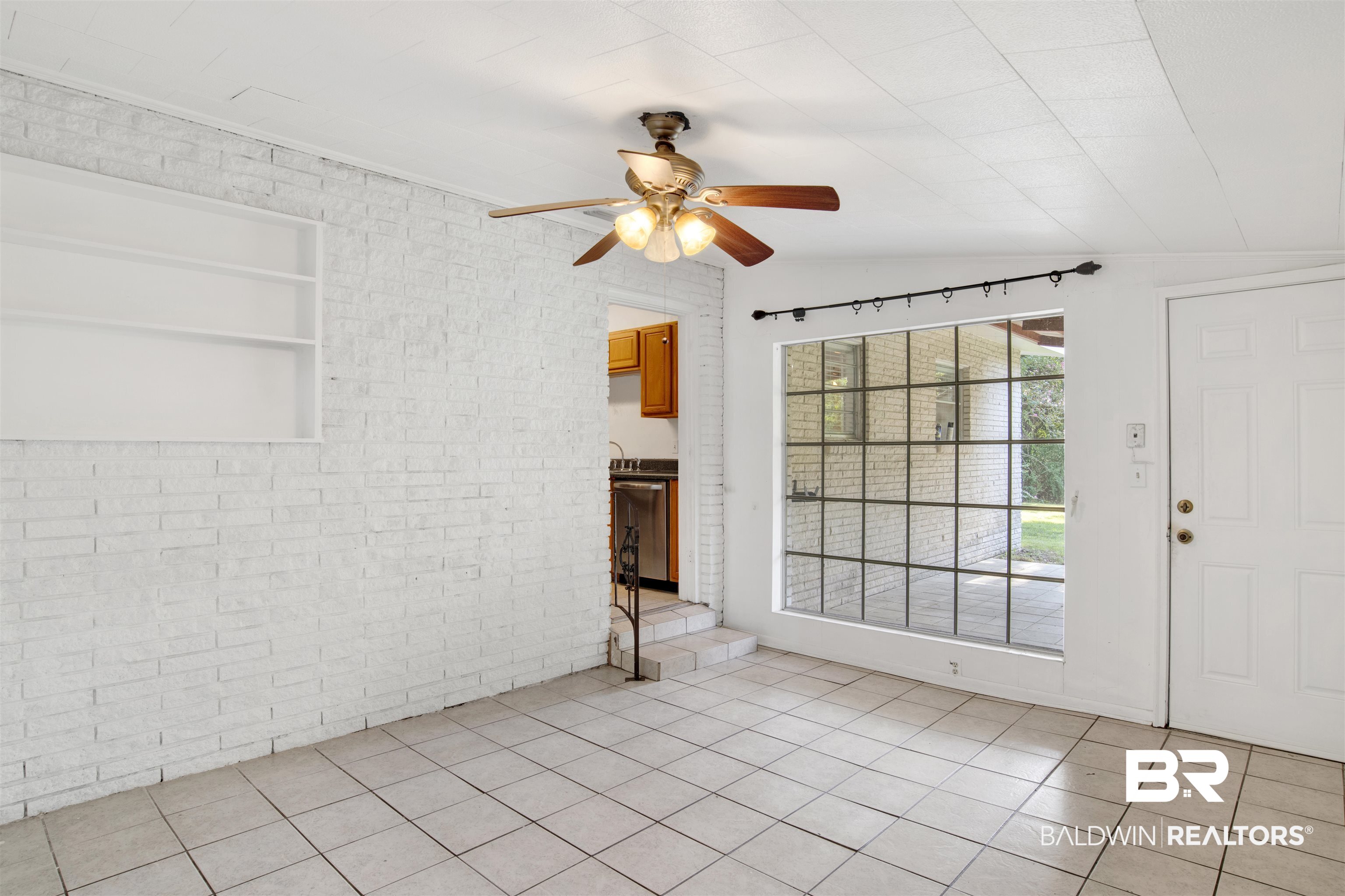 2 Lee Circle Daphne, AL 36527 - Photo 9 of 21 Empty room featuring ceiling fan, vaulted ceiling, light tile patterned floors, and brick wall