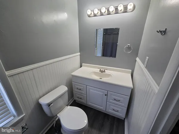 a bathroom with a toilet a sink a mirror a vanity and window