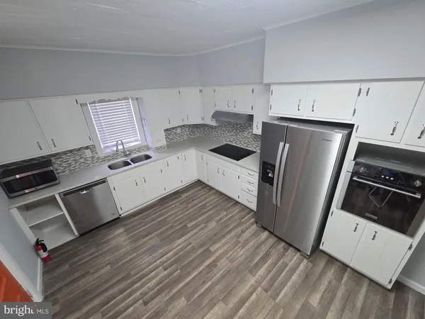 a kitchen with granite countertop white cabinets and steel appliances