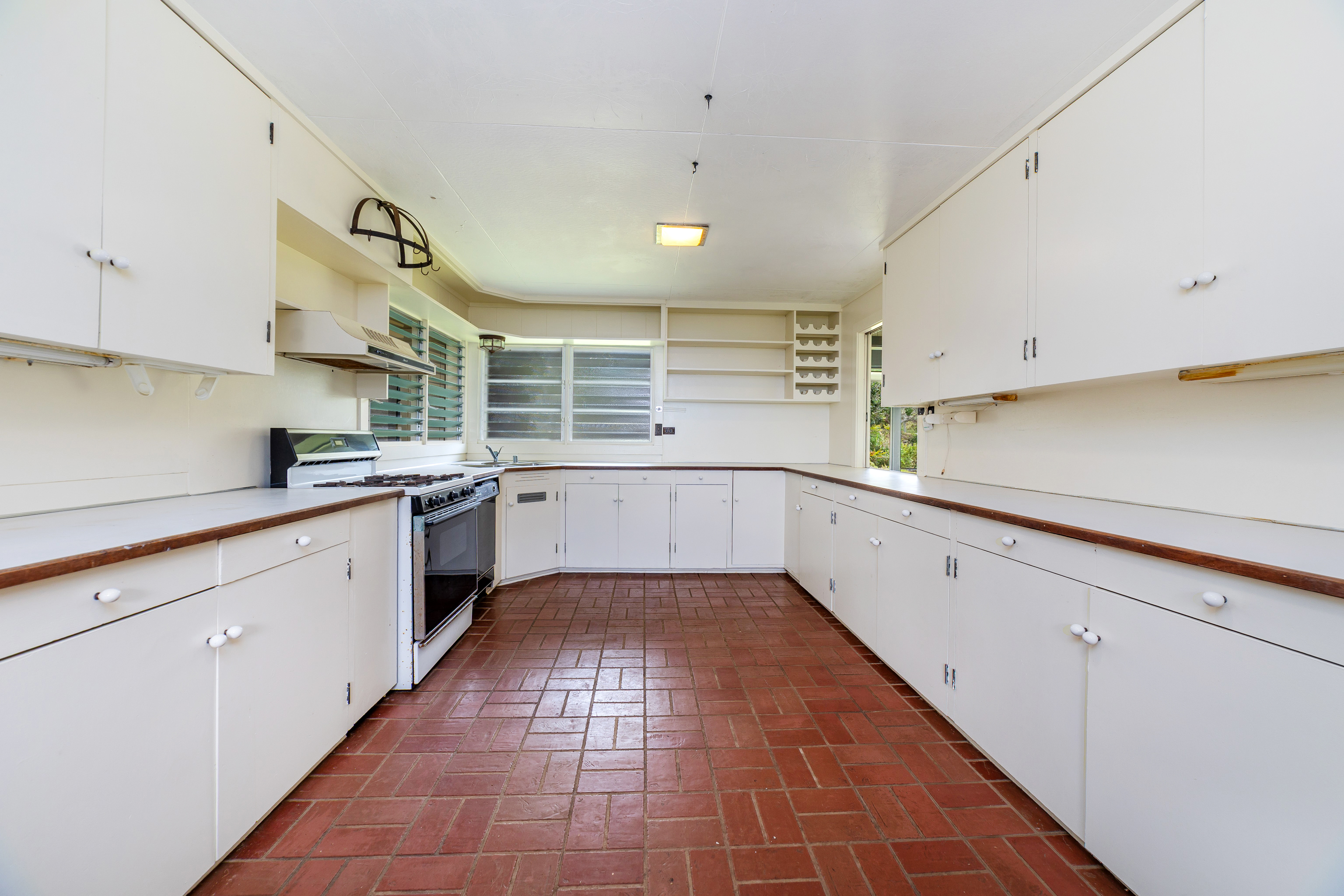 86-4190 Hookena Beach Road Captain Cook, HI 96704 - Photo 10 of 30 a kitchen with a sink a stove and cabinets