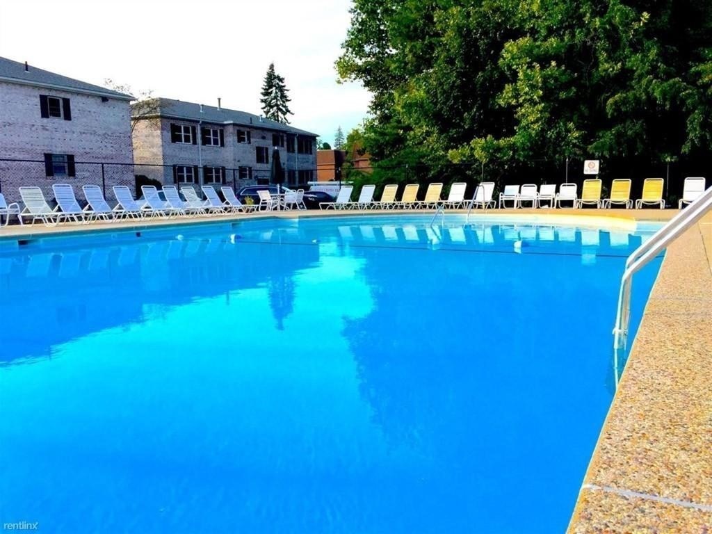 211 Lake Shore Road, Unit 2 Boston, MA 02135 - Photo 11 of 15 a view of swimming pool with outdoor seating and a garden