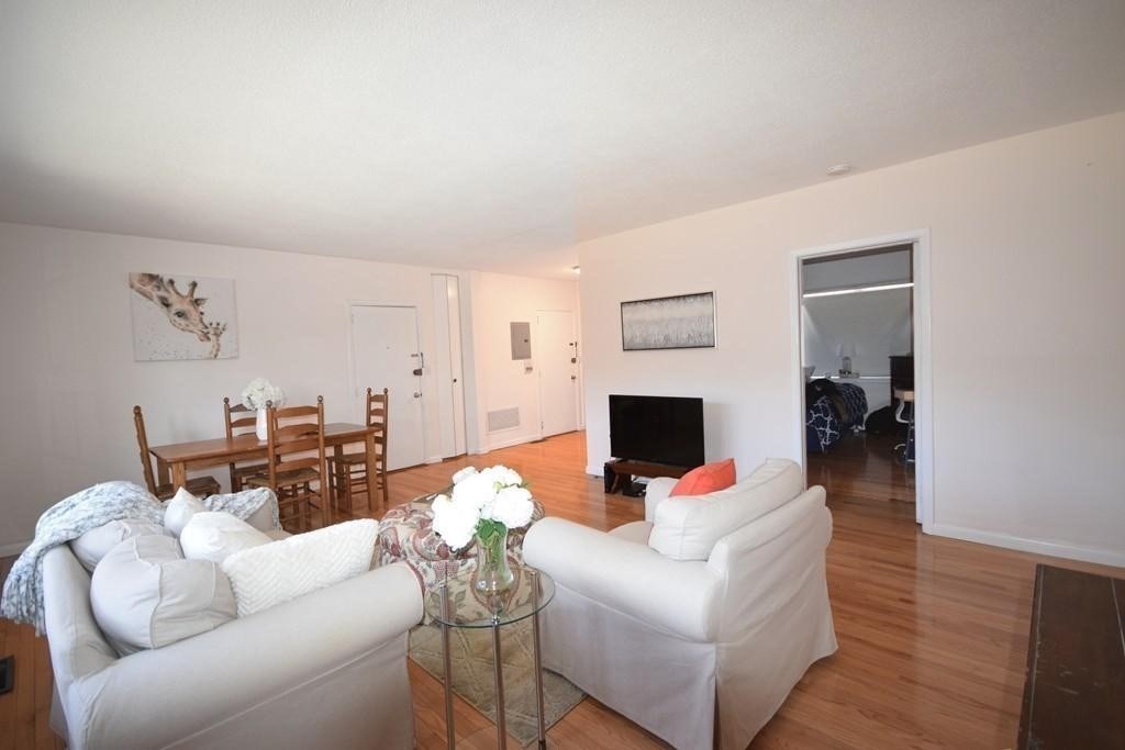 211 Lake Shore Road, Unit 2 Boston, MA 02135 - Photo 2 of 15 a living room with furniture a fireplace and a flat screen tv