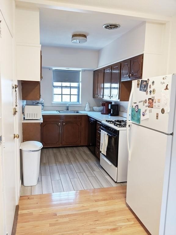 211 Lake Shore Road, Unit 2 Boston, MA 02135 - Photo 3 of 15 a kitchen with stainless steel appliances granite countertop a sink stove and refrigerator