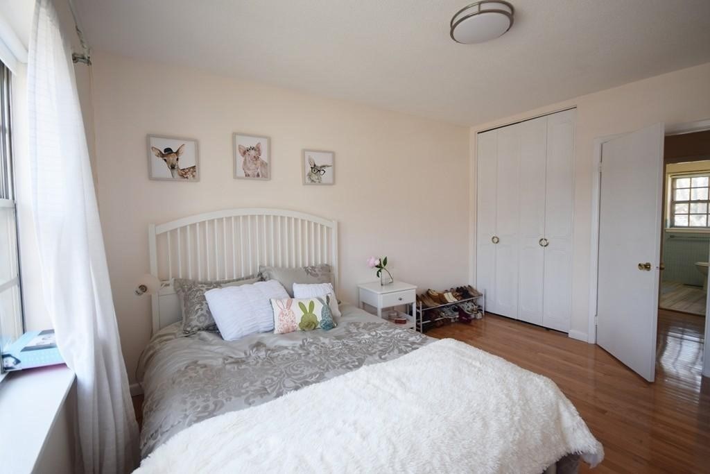 211 Lake Shore Road, Unit 2 Boston, MA 02135 - Photo 5 of 15 a bedroom with a bed and wooden floor