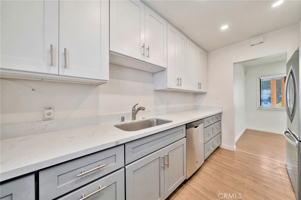 5729 Clemson Street Los Angeles, CA 90016 - Photo 16 of 26 a kitchen with granite countertop white cabinets and a sink