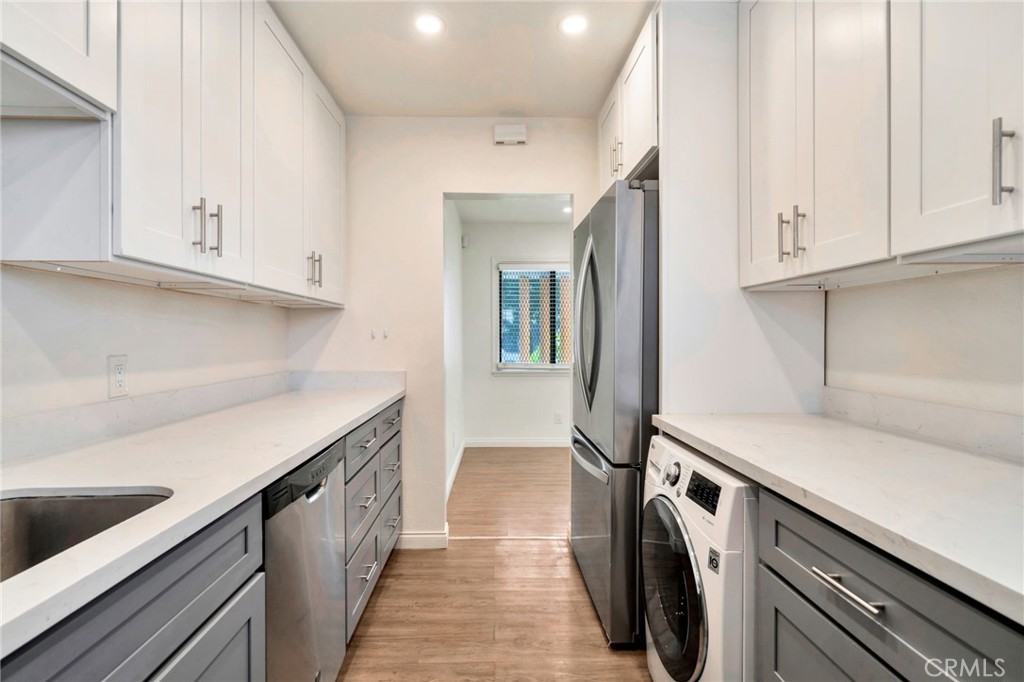 5729 Clemson Street Los Angeles, CA 90016 - Photo 17 of 26 a storage room with wooden floor washer and dryer