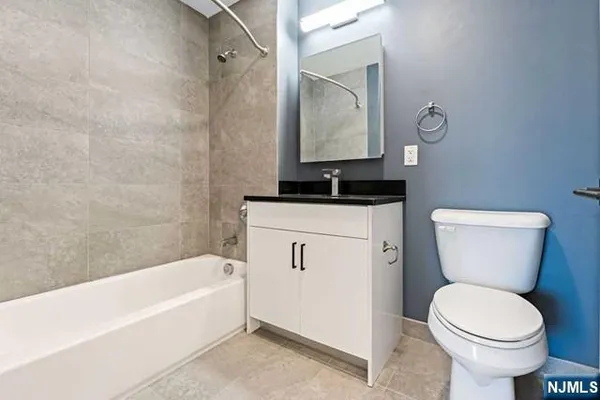 a bathroom with a granite countertop toilet a sink and mirror