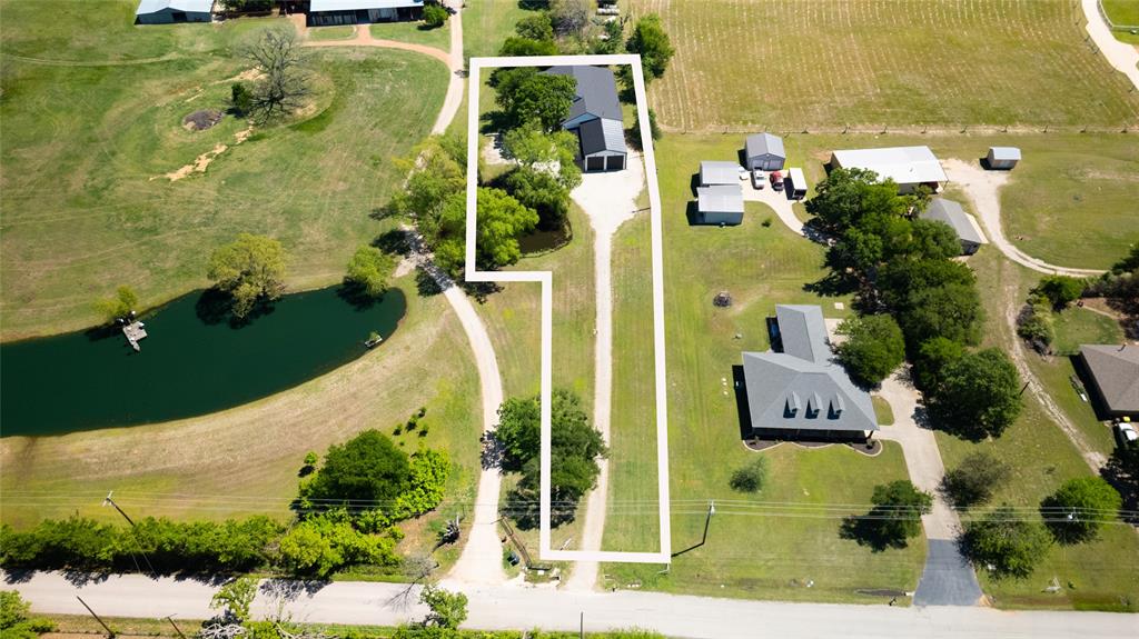 an aerial view of residential house with pool and yard