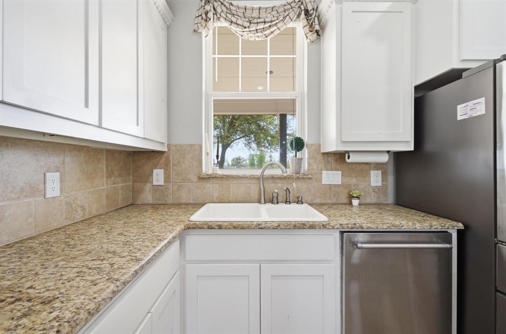5480 New Hope Road Aubrey, TX 76227 - Photo 12 of 39 a kitchen with granite countertop a sink window and cabinets