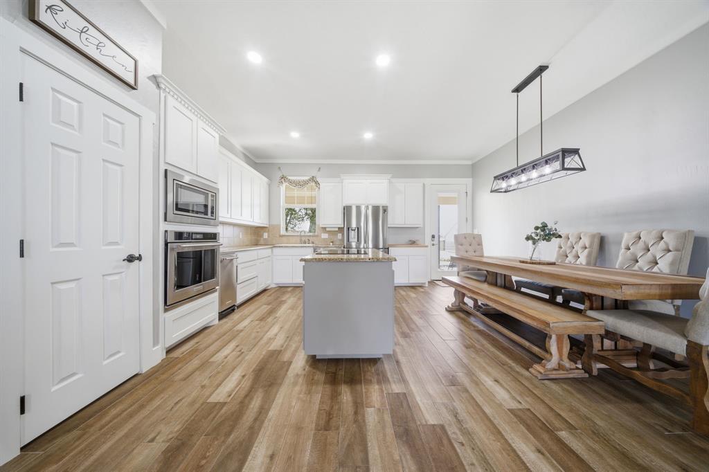 5480 New Hope Road Aubrey, TX 76227 - Photo 14 of 39 a kitchen with stainless steel appliances granite countertop a refrigerator a stove and a wooden floors