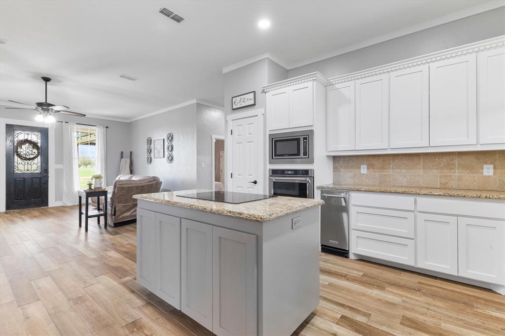 5480 New Hope Road Aubrey, TX 76227 - Photo 14 of 39 a kitchen with granite countertop cabinets a sink and a stove