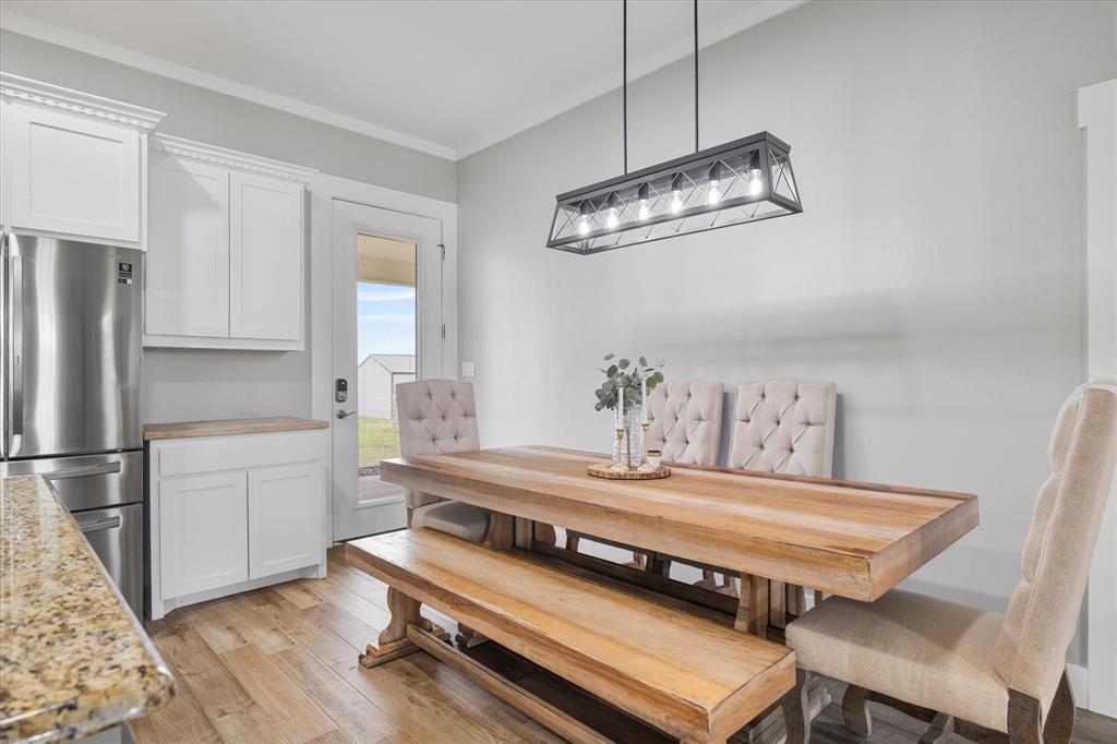5480 New Hope Road Aubrey, TX 76227 - Photo 15 of 39 Dining space with light wood-style flooring and crown molding
