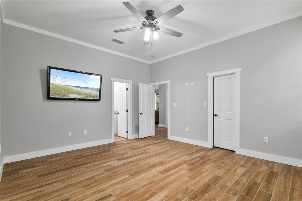 5480 New Hope Road Aubrey, TX 76227 - Photo 16 of 39 a view of a room with wooden floor and a ceiling fan
