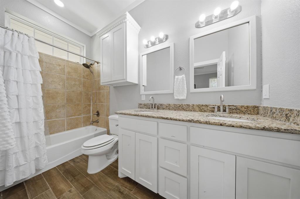 5480 New Hope Road Aubrey, TX 76227 - Photo 17 of 39 a bathroom with a granite countertop sink toilet a mirror and shower