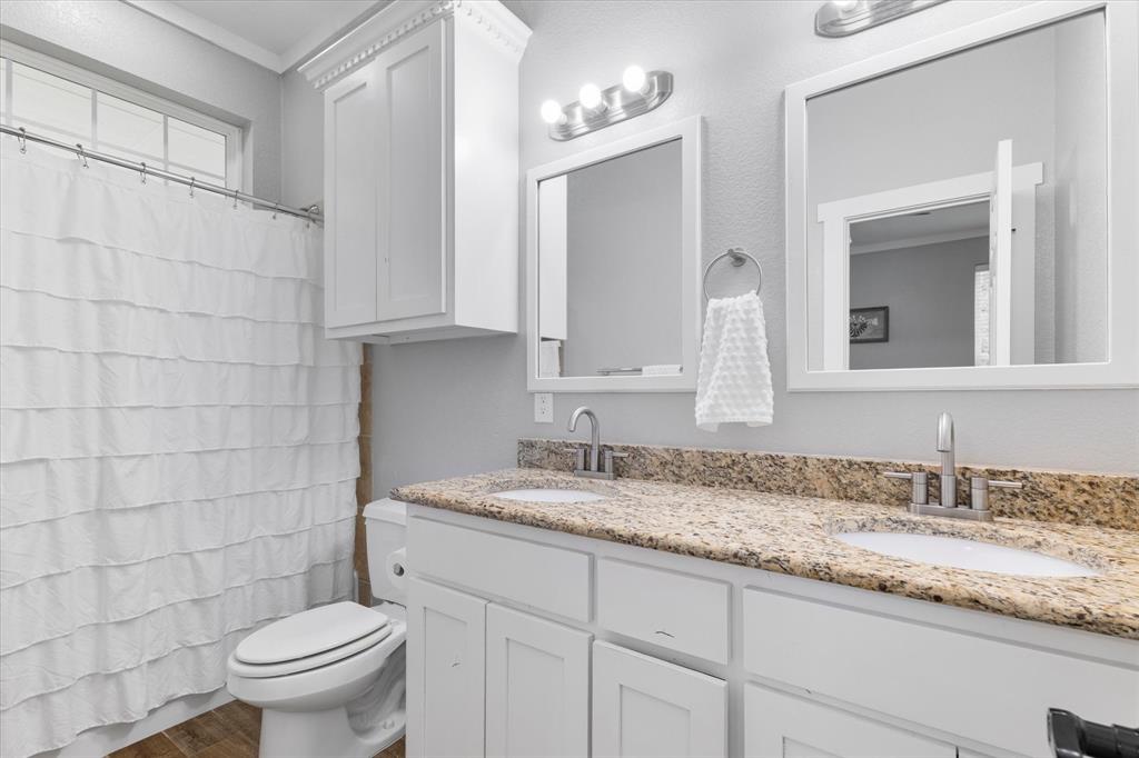 5480 New Hope Road Aubrey, TX 76227 - Photo 17 of 39 a bathroom with a granite countertop sink a toilet and a mirror