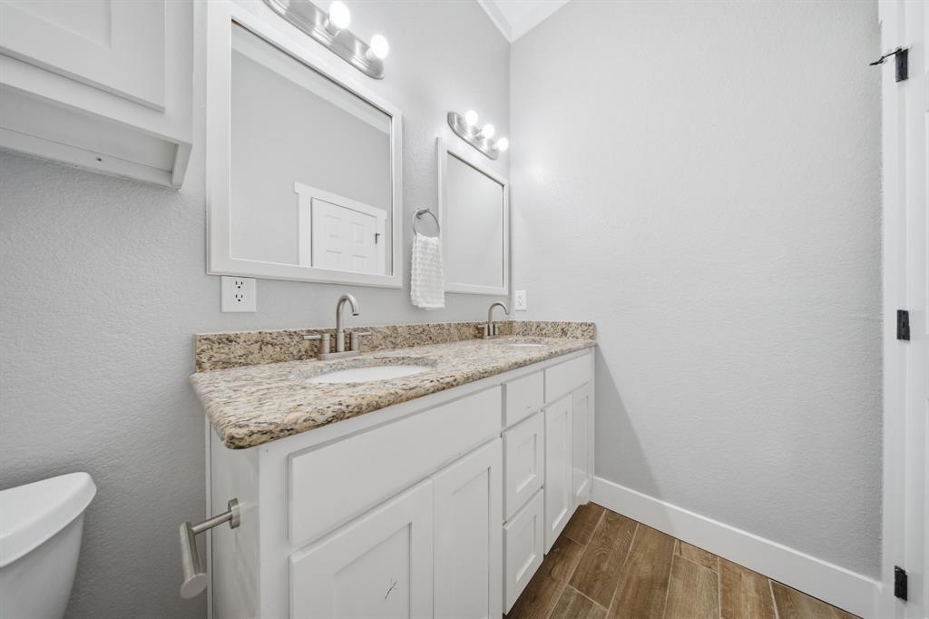5480 New Hope Road Aubrey, TX 76227 - Photo 18 of 39 a bathroom with a granite countertop sink a toilet and a mirror