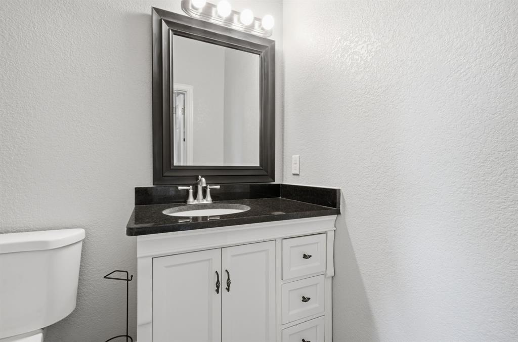 5480 New Hope Road Aubrey, TX 76227 - Photo 20 of 39 a bathroom with a granite countertop sink and a toilet