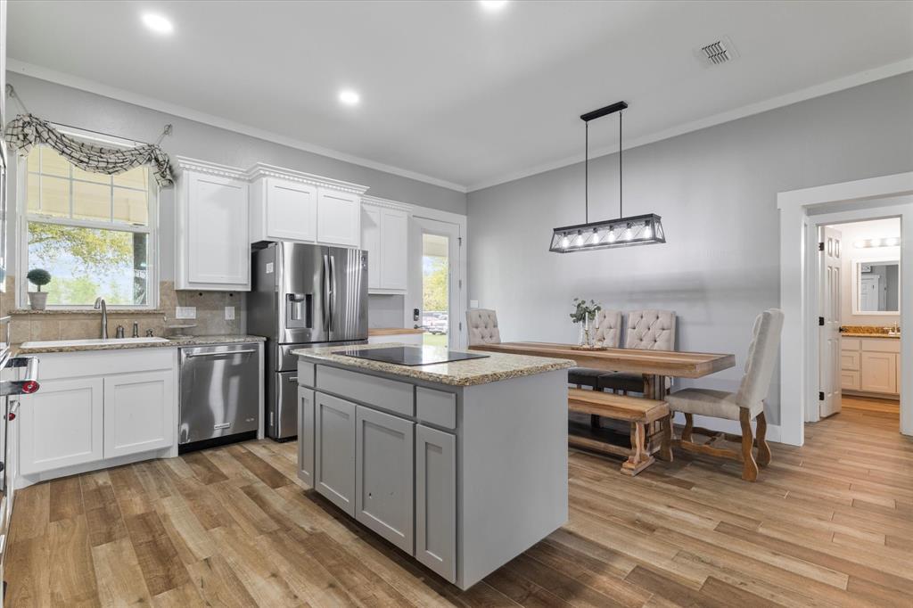 5480 New Hope Road Aubrey, TX 76227 - Photo 2 of 39 a kitchen with refrigerator cabinets and wooden floor