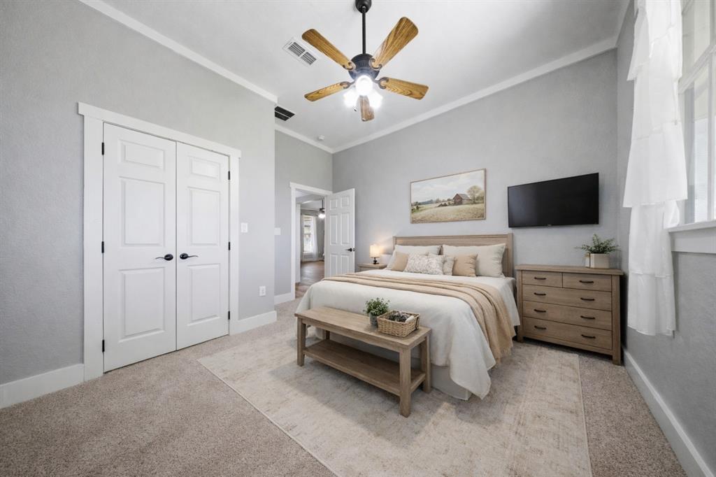 5480 New Hope Road Aubrey, TX 76227 - Photo 22 of 39 a spacious bedroom with a bed and a flat screen tv