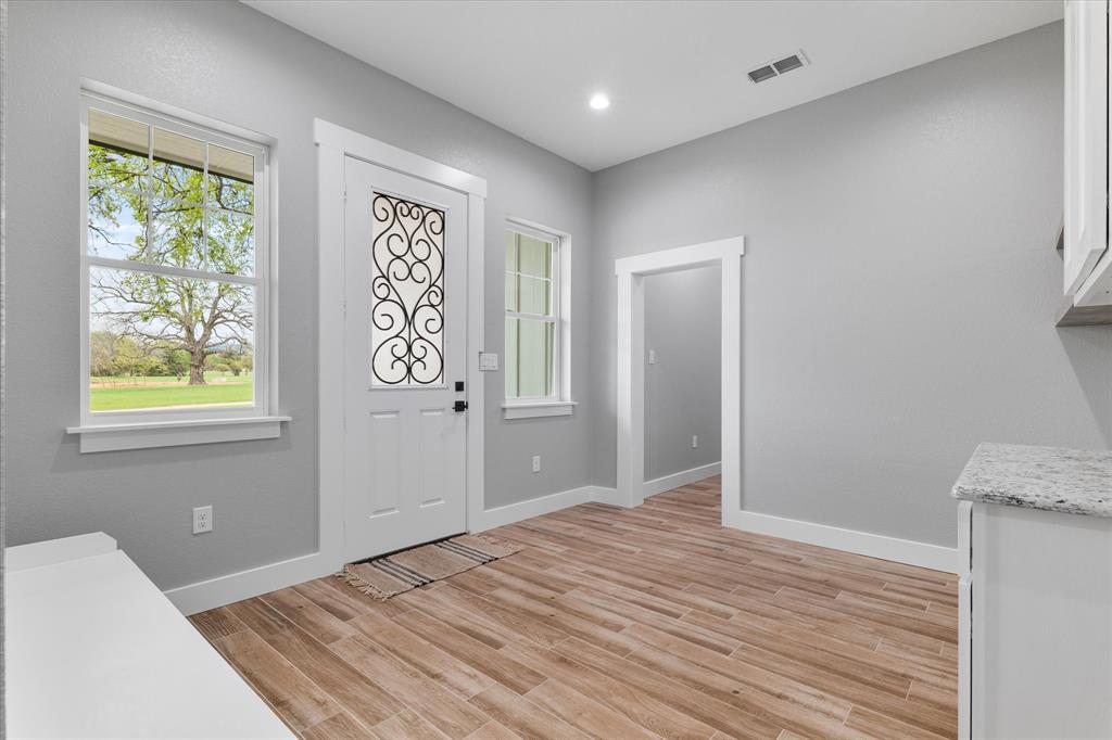 5480 New Hope Road Aubrey, TX 76227 - Photo 24 of 39 a view of an empty room with wooden floor and a window