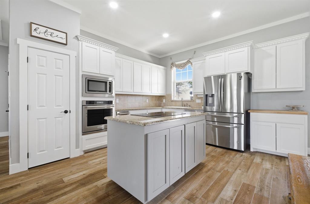 5480 New Hope Road Aubrey, TX 76227 - Photo 10 of 39 a kitchen with a refrigerator stove and sink