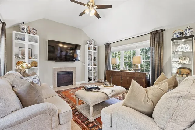 a living room with furniture a fireplace and a flat screen tv