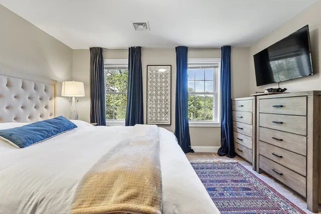 a bedroom with a large bed and a flat tv screen