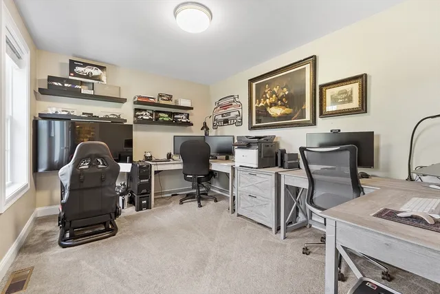 a view of workspace with lounge chair and windows