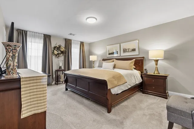 a bedroom with a bed lamp and a dresser