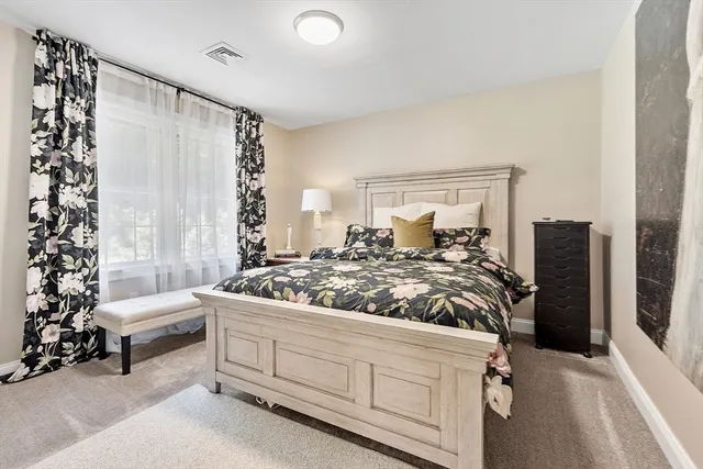 a large bed sitting in a bedroom next to a window and a chandelier