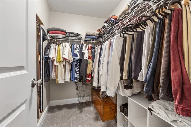 a view of walk in closet with clothes and shoes
