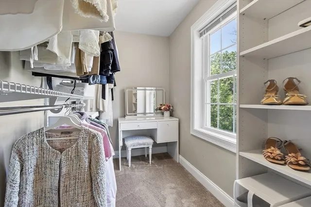a view of walk in closet with clothes and shoes