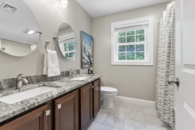 a bathroom with a granite countertop sink a toilet and a mirror