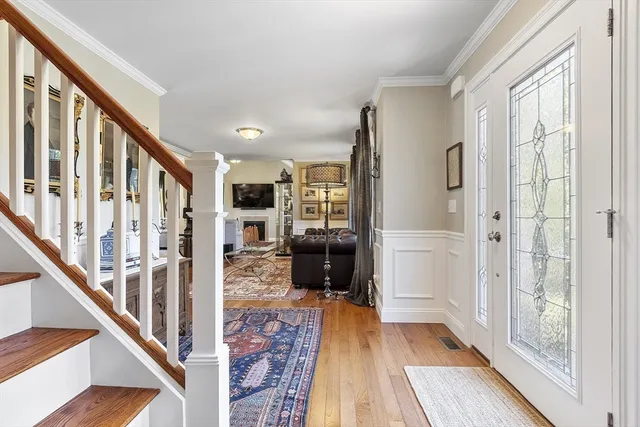 a view of a hallway with wooden floor and staircase
