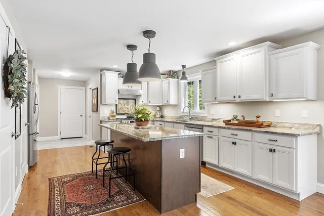 a kitchen with stainless steel appliances granite countertop a sink stove and refrigerator