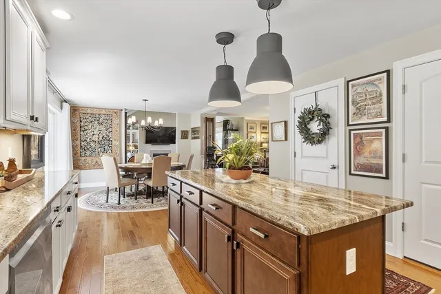 a open kitchen with granite countertop a stove and a wooden floors