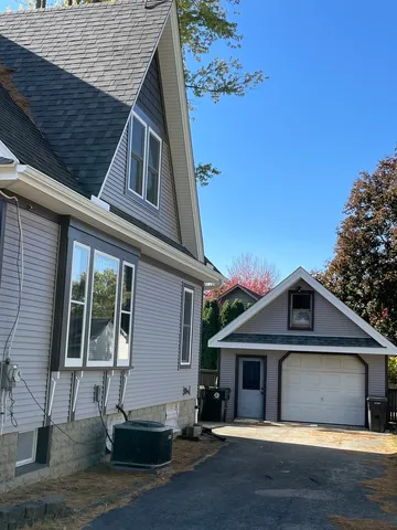 a view of a house with a yard and large tree