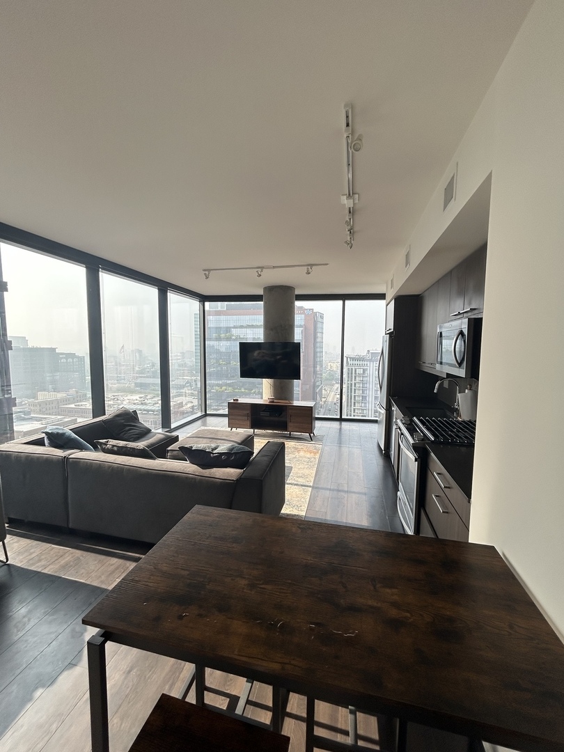 730 West Couch Place, Unit 1805 Chicago, IL 60661 - Photo 2 of 9 a living room with furniture and a flat screen tv