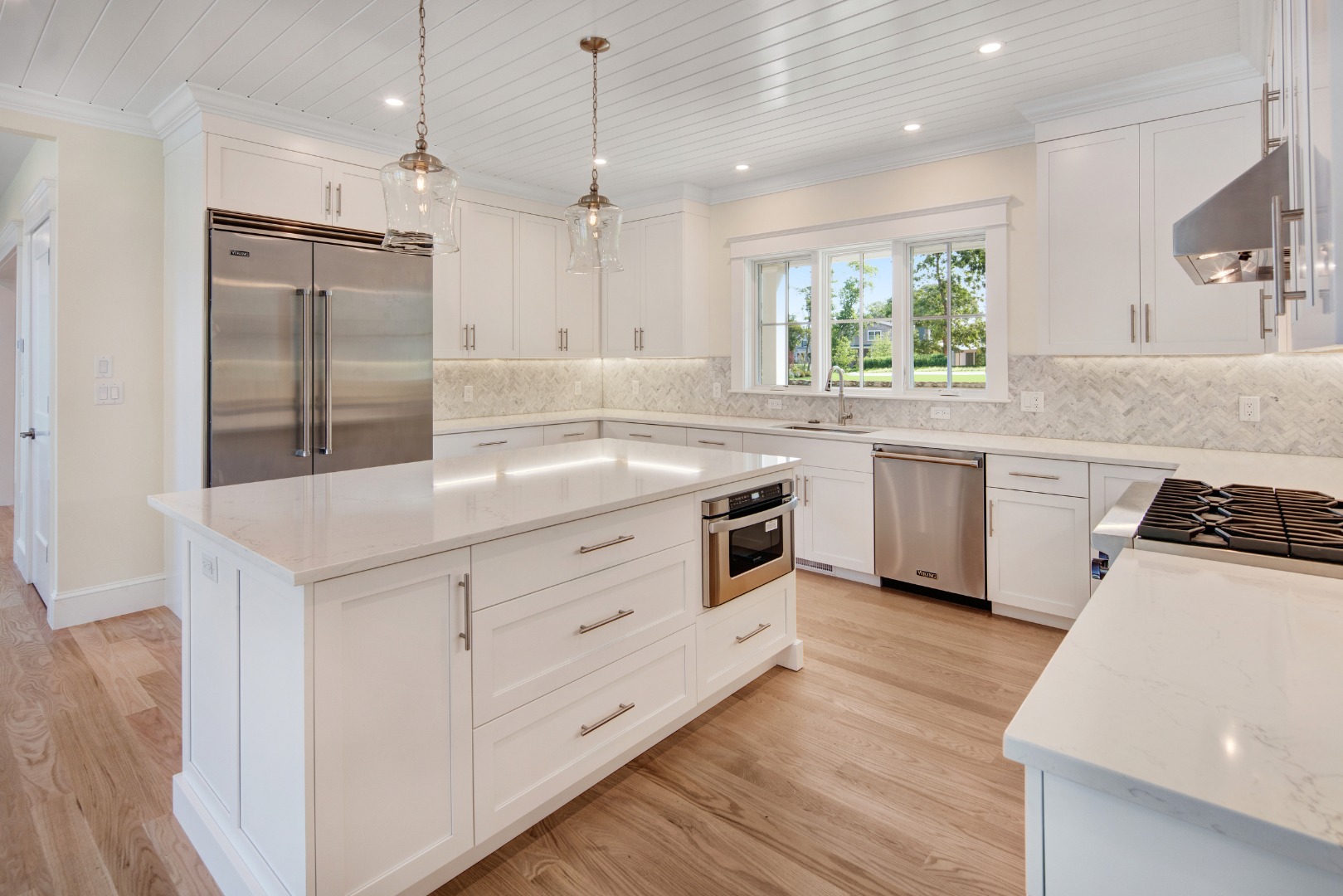 1 Wilsons Lane Edgartown, MA 02539 - Photo 4 of 18 a kitchen with granite countertop a sink stove a refrigerator and white cabinets with wooden floor