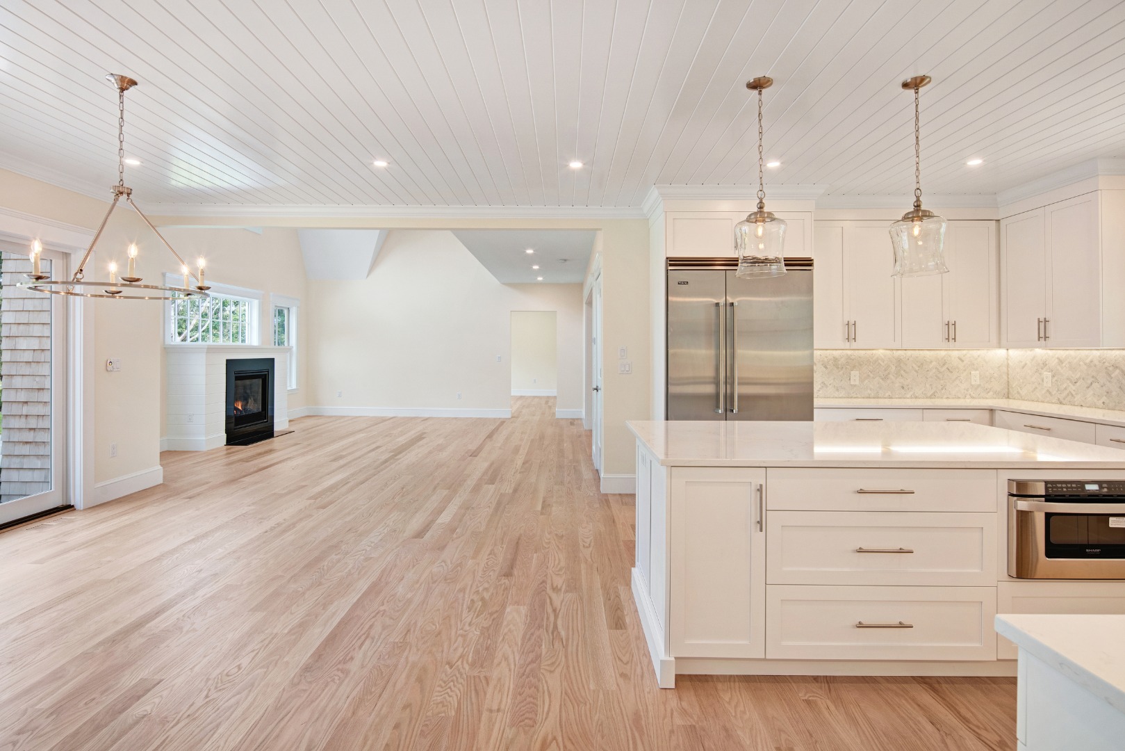 1 Wilsons Lane Edgartown, MA 02539 - Photo 6 of 18 a open kitchen with kitchen island a stove a refrigerator wooden floor and white cabinets