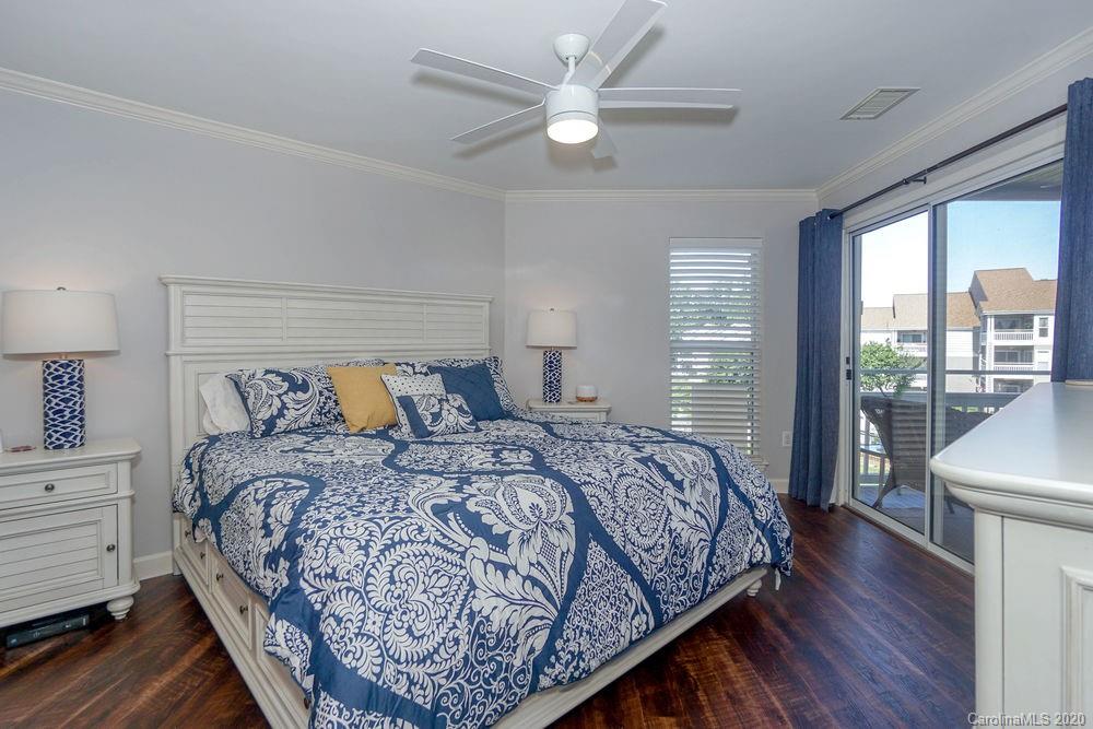 1114 Torrence Circle, Unit 1114 Davidson, NC 28036 - Photo 13 of 29 a bedroom with a large bed and a chandelier fan