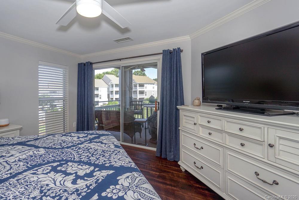 1114 Torrence Circle, Unit 1114 Davidson, NC 28036 - Photo 14 of 29 a bedroom with a bed and a flat screen tv