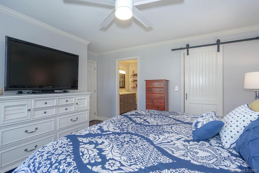 1114 Torrence Circle, Unit 1114 Davidson, NC 28036 - Photo 16 of 29 a bedroom with a bed and a flat screen tv