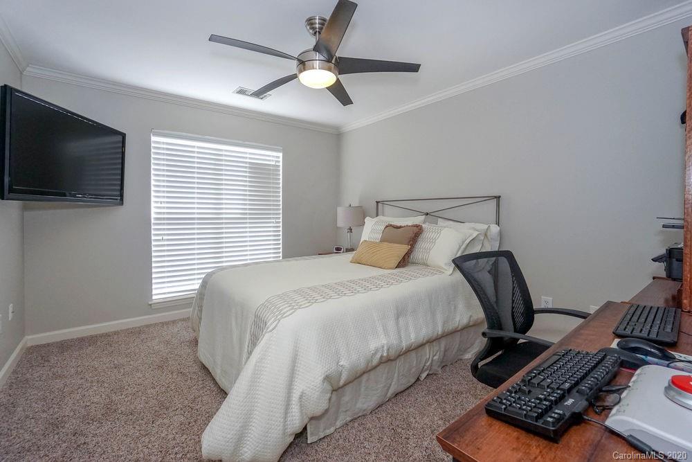 1114 Torrence Circle, Unit 1114 Davidson, NC 28036 - Photo 20 of 29 a bedroom with a bed and a flat screen tv